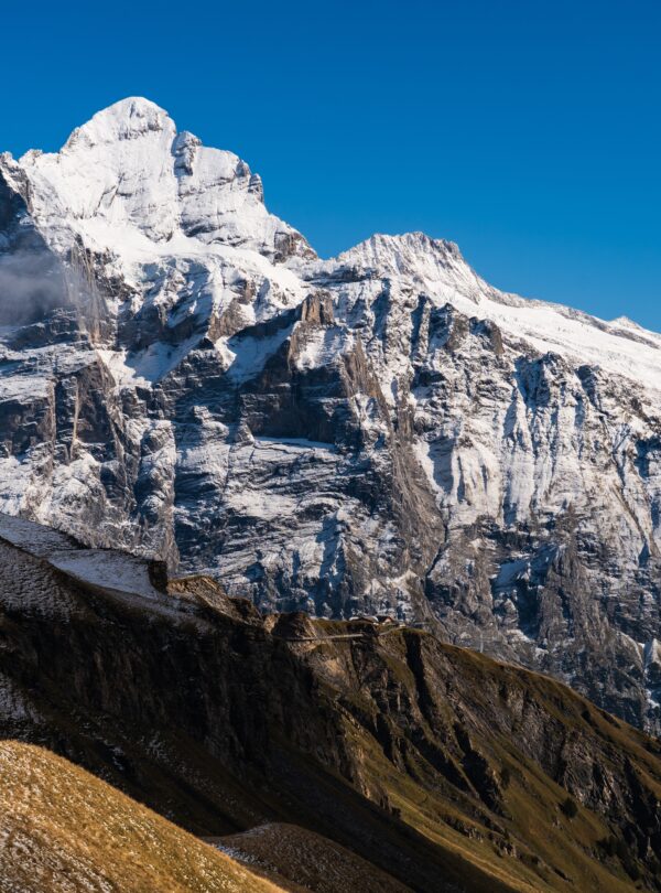 High rocky mountains covered with snow under a clear blue sky in Switzerland