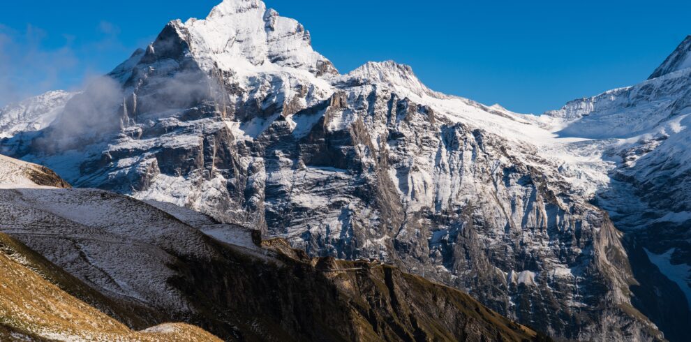 High rocky mountains covered with snow under a clear blue sky in Switzerland